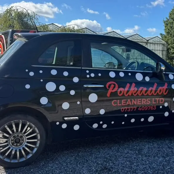 The black Polka Dot Cleaners car with white polka dots and the company name and phone number