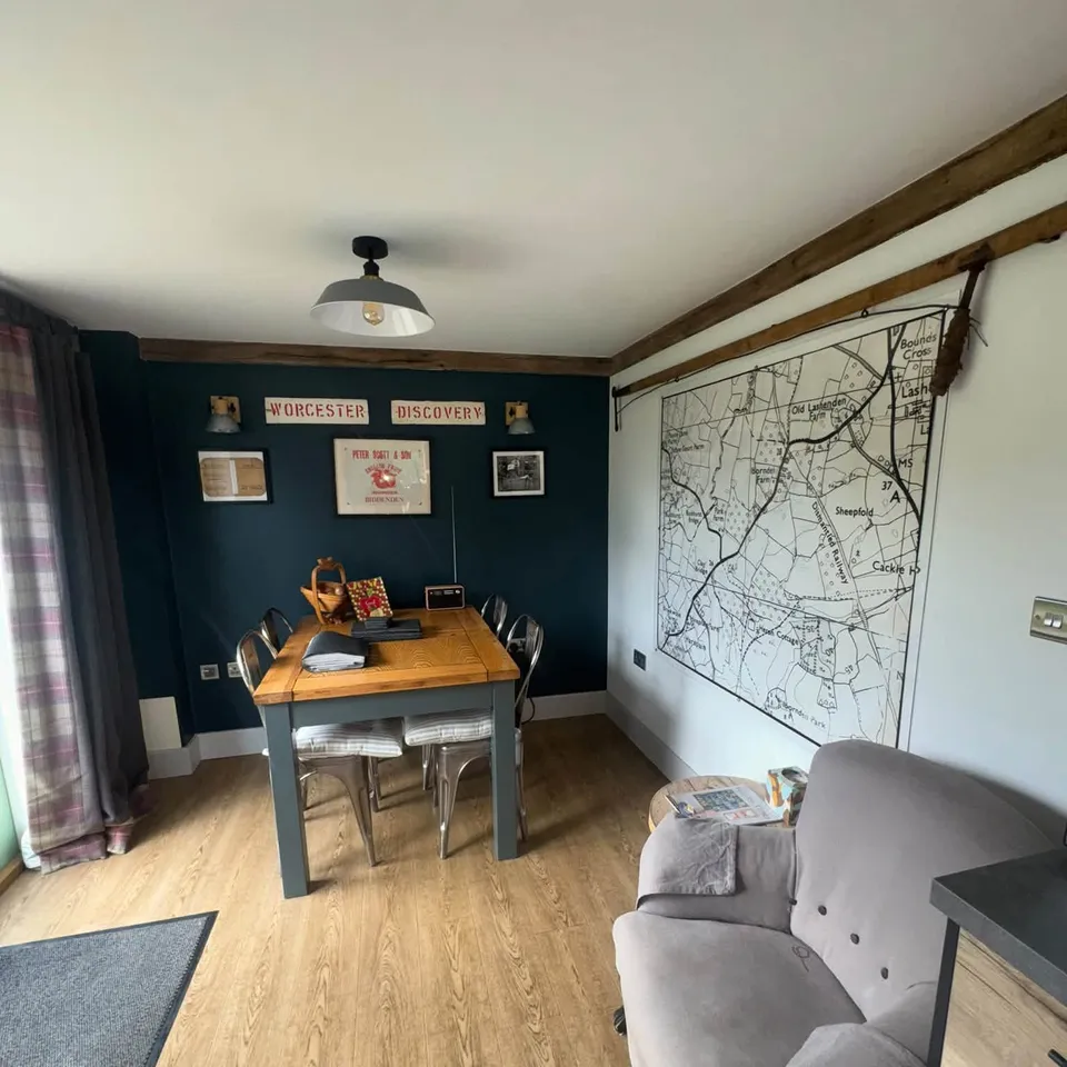 A dining area with a wooden table and chairs, left clean and tidy