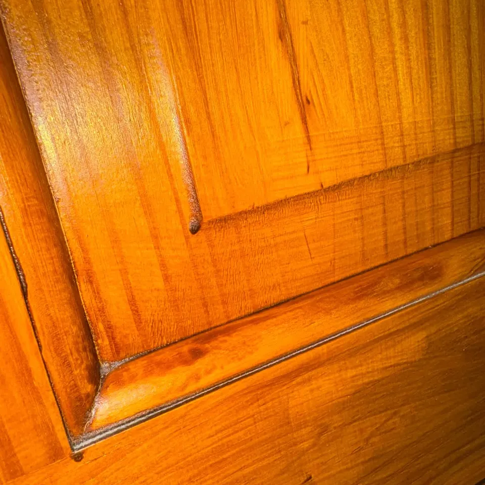 The same wooden door panel cleaned and polished to a rich shine