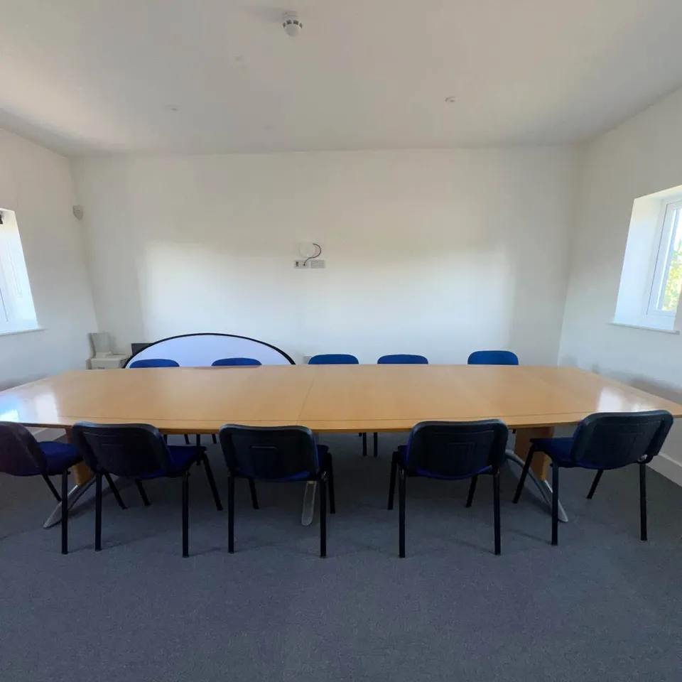 An office meeting room with a long table and chairs after a commercial clean
