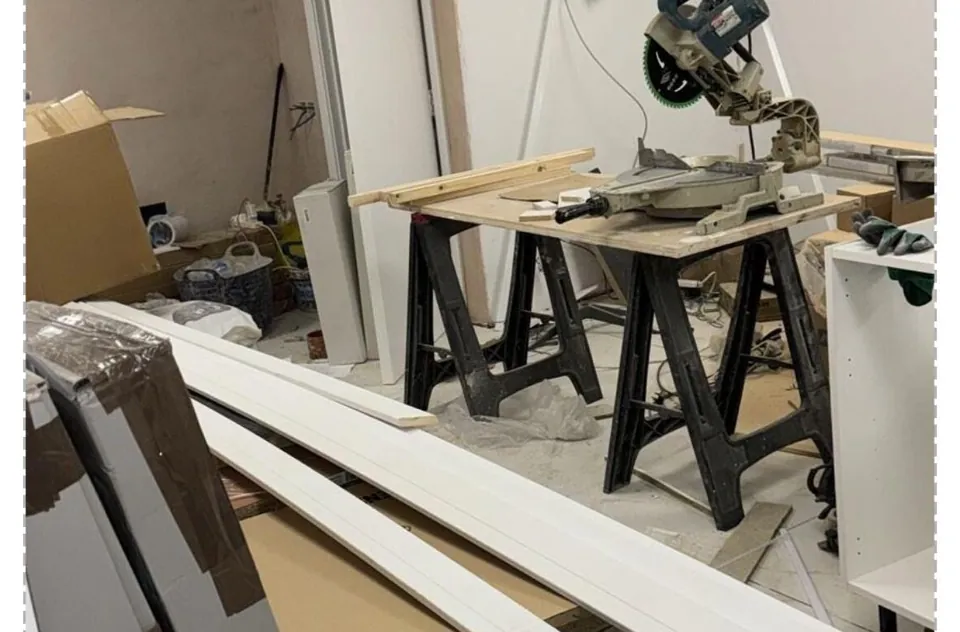 A commercial unit during building work, with sawhorses, timber and dust on the floor